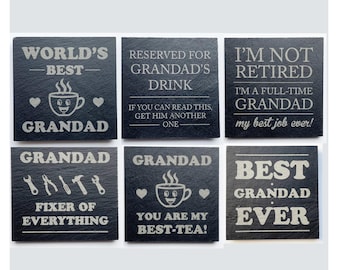 May include: Six black slate coasters with white engraved text. The coasters have various messages for a grandfather, including "World's Best Grandad," "Reserved for Grandad's Drink," and "Best Grandad Ever." Some feature a teacup graphic.