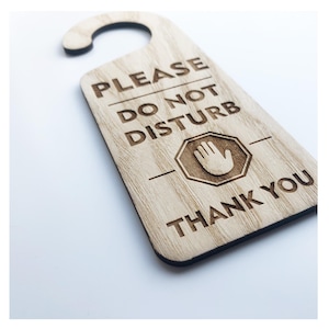 May include: Wooden door hanger with the text "Please Do Not Disturb" and a stop sign with a hand in it. The text "Thank You" is at the bottom of the hanger.