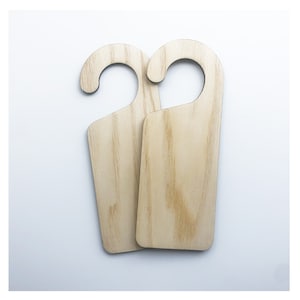 May include: Two unfinished wooden door hangers with a hook at the top. The hangers are rectangular and have a natural wood grain.