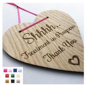 May include: A wooden heart-shaped sign with the text "Shhh... Treatment in Progress Thank You" and a small heart symbol. The sign is hanging from a pink ribbon.