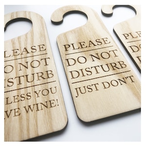 May include: Three wooden door hangers with the text "Please Do Not Disturb" and "Just Don't" and "Please Do Not Disturb Unless You Have Wine!"