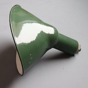 May include: A green enamel lampshade with a white interior. The shade has a rounded shape and a metal fitting.
