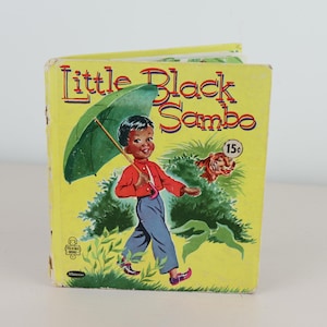 May include: A white ceramic mug with a black handle and the text "But First, Coffee" in a black, handwritten-style font. The mug is on a white surface.