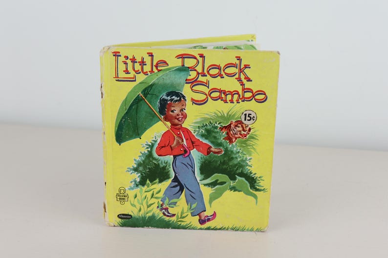 May include: A white ceramic mug with a black handle and the text "But First, Coffee" in a black, handwritten-style font. The mug is on a white surface.