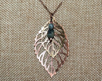 Copper and bronze layered filigree leaf long necklace with white and green stones and copper bead dangle