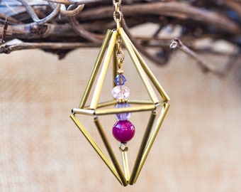 Geometric brass tube ornament with purple bead and pink and purple crystal beaded dangle inside