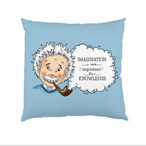 Op de afbeelding: Een blauw kussen met een cartoonillustratie van Albert Einstein die een pijp rookt en nadenkt in een gedachtewolk. De gedachtewolk zegt "Fantasie is belangrijker dan kennis."