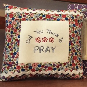 May include: Three framed pieces of embroidery with religious themes. The first is a pillow with a floral pattern and the text "Did you think to pray". The second is a white frame with the text "I will follow God's plan for me". The third is a brown frame with a pink background and the text "CTR" inside a heart.