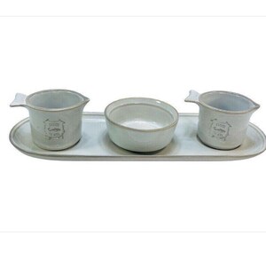 May include: A white ceramic serving tray with three white ceramic bowls. The bowls have a fish design and the text "From the Sea" on them.