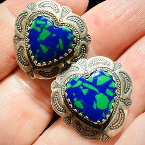 May include: A pair of silver heart-shaped earrings with blue and green stone inlays.