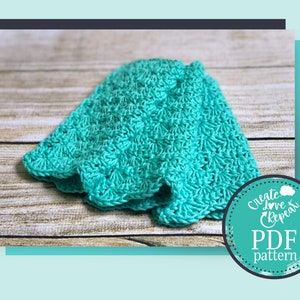 May include: A teal crochet blanket with a scalloped edge. The blanket is folded and lying on a wooden surface. The image includes the text "Create Love Repeat PDF pattern".