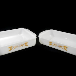 May include: Two white rectangular baking dishes with gold wheat designs.