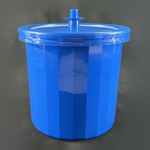 May include: A blue plastic container with a lid. The container has vertical ridges and a smooth, shiny surface.