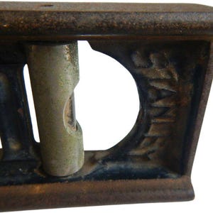 May include: A vintage cast iron level with two spirit levels and the word "Stanley" embossed on the side.