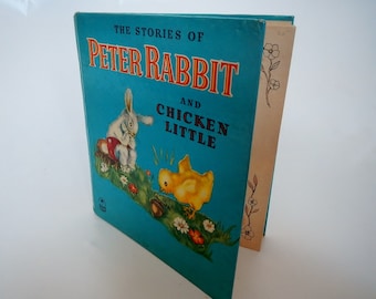 May include: A blue book with the title "The Stories of Peter Rabbit and Chicken Little" on the cover. The cover features illustrations of a white rabbit and a yellow chick.