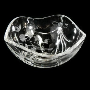 May include: A clear glass bowl with a wavy rim and an etched floral design.