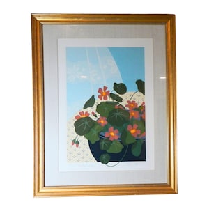 May include: A framed print of a still life featuring a potted plant with pink flowers and green leaves against a blue and white background.