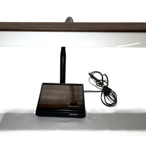 May include: A vintage brown and black desk lamp with a white light panel and a black cord. The lamp has a woodgrain base and the brand name "Tansor" is visible on the base.