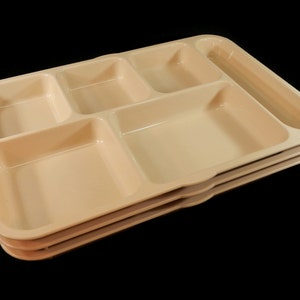 May include: A stack of three beige plastic divided trays. The trays have five compartments, including a long, narrow compartment.