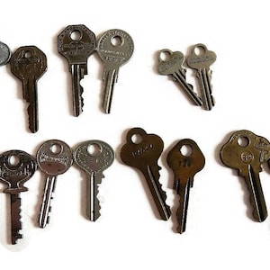 May include: A collection of vintage keys, some with brass finishes and others with silver finishes. The keys have various shapes and sizes, and some have markings on them.