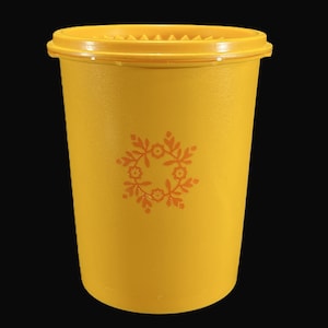 May include: A yellow plastic container with a lid and a floral design in orange. The container is about 6 inches tall.