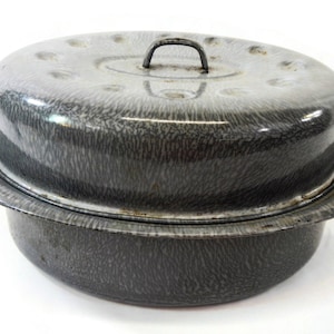 Peut inclure: Une marmite de cuisine vintage en émail gris avec un couvercle. Le pot présente un motif moucheté et une poignée métallique sur le couvercle. Le pot a deux poignées sur les côtés. Le pot est probablement utilisé pour la cuisine.