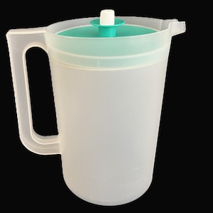May include: A clear plastic pitcher with a light green lid and handle. The pitcher has a capacity of approximately 2 quarts. The handle is sturdy and easy to grip. The lid has a small, white, circular stopper.