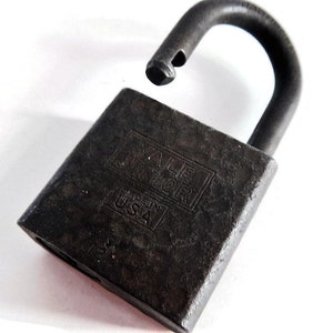 May include: A black metal padlock with the text "Yale" and "USA" on the front. The padlock is open and the shackle is raised.