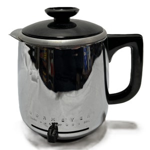 May include: A vintage chrome Dormeyer electric coffee pot with a black lid and handle. The coffee pot has a spout and a temperature control dial. The words "Dormeyer" and "Warm, Hot, Boil" are printed on the front.