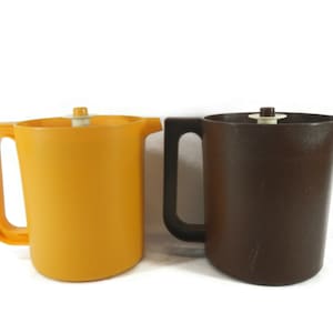 May include: Two plastic pitchers, one yellow and one brown, with lids and handles.