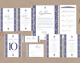 May include: A collection of wedding stationery featuring a blue and white floral design. The set includes invitations, a welcome card, a schedule of events, table cards, a menu, and RSVP cards. Gold scissors and rings are also present.