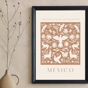 Puede incluir: Una impresión enmarcada con un fondo marrón y diseños florales y animales blancos. El texto "A vibrant blend of culture, traditions and history" y "MÉXICO" están impresos en blanco en la parte superior e inferior de la impresión.