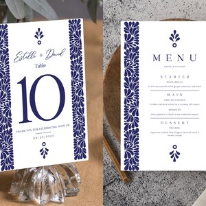 May include: A white wedding table number card with a blue floral border and the text "Estrella & David Table 10 Thank you for celebrating with us 09.23.2021".