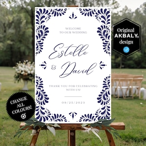 Puede incluir: Un cartel de bienvenida de boda blanco con un diseño floral azul. El cartel dice "Bienvenido a nuestra boda Estelle & David ¡Gracias por celebrar con nosotros! 09/25/2023".