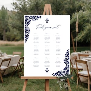 Peut inclure: Plan de table de mariage blanc avec des motifs floraux bleus. Le tableau est intitul&eacute; "Trouvez votre place" et liste les noms des invit&eacute;s par num&eacute;ro de table.