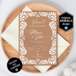 May include: A wedding invitation with a brown background and white floral border. The text includes the names "Maria & John" and the date "September 25, 2023". The invitation is on a wooden plate with an envelope.