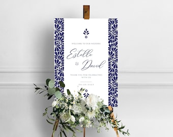 May include: White wedding welcome sign with a navy blue floral border. The sign reads "Welcome to our wedding Estelle & David Thank you for celebrating with us 09/25/2023"