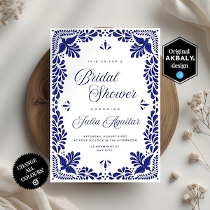 May include: A white invitation with blue floral border and text for a bridal shower. The invitation reads "Bridal Shower" and includes the name "Julia Aguilar" and event details. The design includes the text "Original AKBALY design".