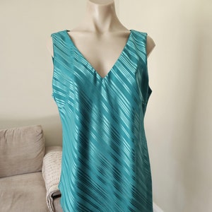 May include: A sleeveless teal blue top with a V-neck and a diagonal striped pattern.