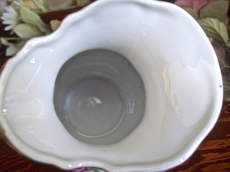 Peut inclure: Pichet en porcelaine blanche avec un bord festonn&eacute; et un motif floral. Le pichet a une large ouverture et un int&eacute;rieur blanc lisse.
