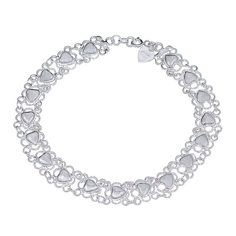 May include: Silver bracelet with a double row of heart-shaped links. The bracelet has a lobster clasp and a small heart-shaped tag with the inscription "925".