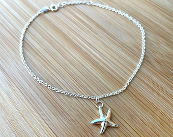 May include: A silver anklet with a starfish charm. The anklet is made of a delicate chain and the starfish is a simple design.