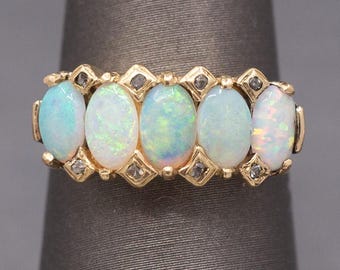 May include: A gold band ring with six oval-shaped opals and small diamonds set in between each opal.