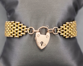 May include: A gold chain bracelet with a heart-shaped padlock clasp. The chain is made of small, interlocking links.