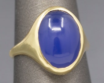 May include: A gold ring with a large oval blue gemstone.