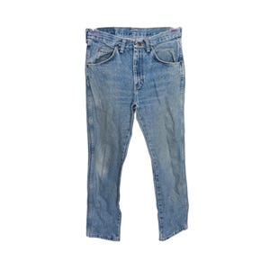 May include: Light blue denim jeans with a classic five-pocket design. The jeans have a straight leg cut and a faded wash, giving them a vintage look. The jeans are made of durable denim material.