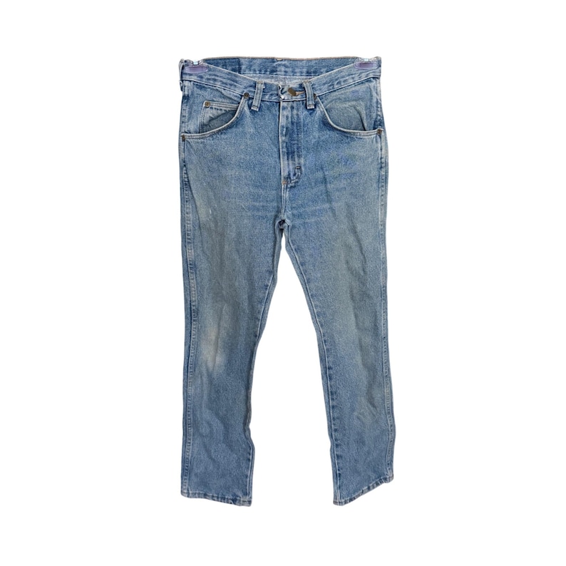 May include: Light blue denim jeans with a classic five-pocket design. The jeans have a straight leg cut and a faded wash, giving them a vintage look. The jeans are made of durable denim material.