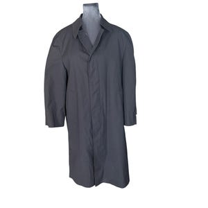 May include: A dark gray, full-length trench coat with a collared neckline and button closure. The coat is displayed on a mannequin and has long sleeves. A classic outerwear garment.