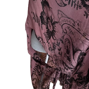 Puede incluir: Una tela de estampado floral rosa y negro con un patr&oacute;n paisley. La tela es suave y fluida, y los colores son apagados y elegantes.