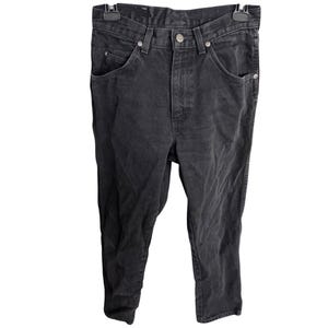 May include: Black denim jeans with a classic five-pocket design. The jeans have a button and zipper closure, belt loops, and a straight leg fit. The fabric appears slightly faded, giving them a worn-in look.